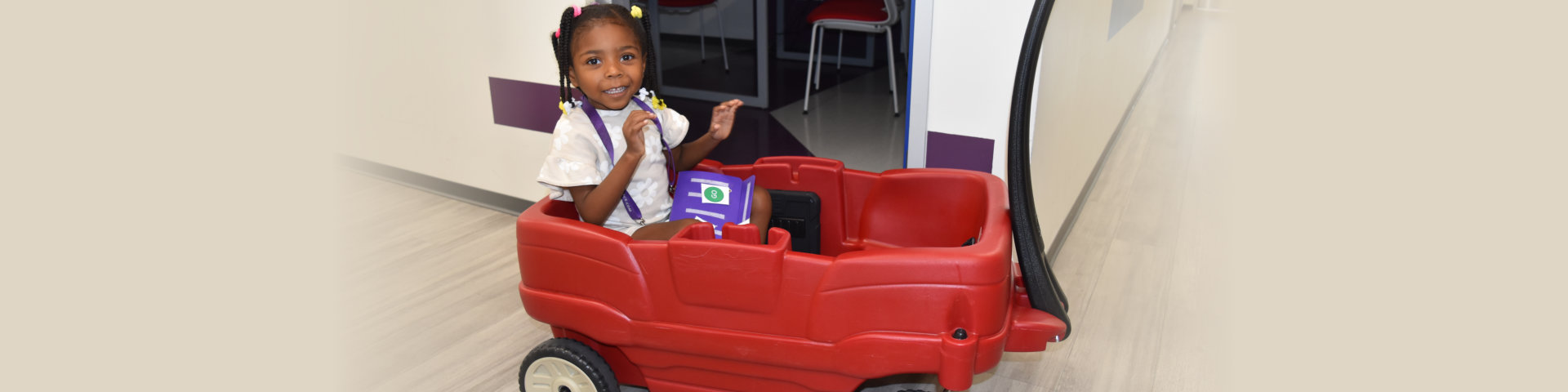 child riding a red toy car